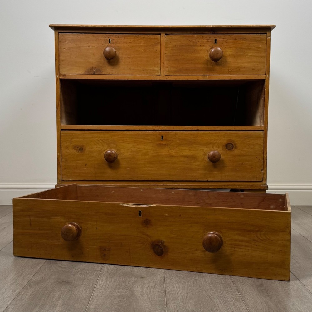 A Victorian pine chest of drawers featuring a two over two drawer layout, turned wooden knobs, and turned feet. View X