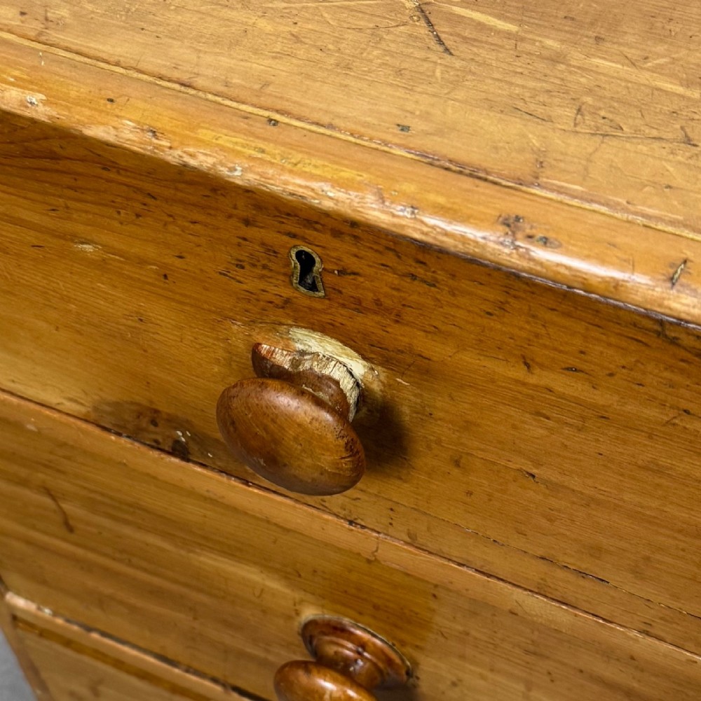 A Victorian pine chest of drawers featuring a two over two drawer layout, turned wooden knobs, and turned feet. View XIII