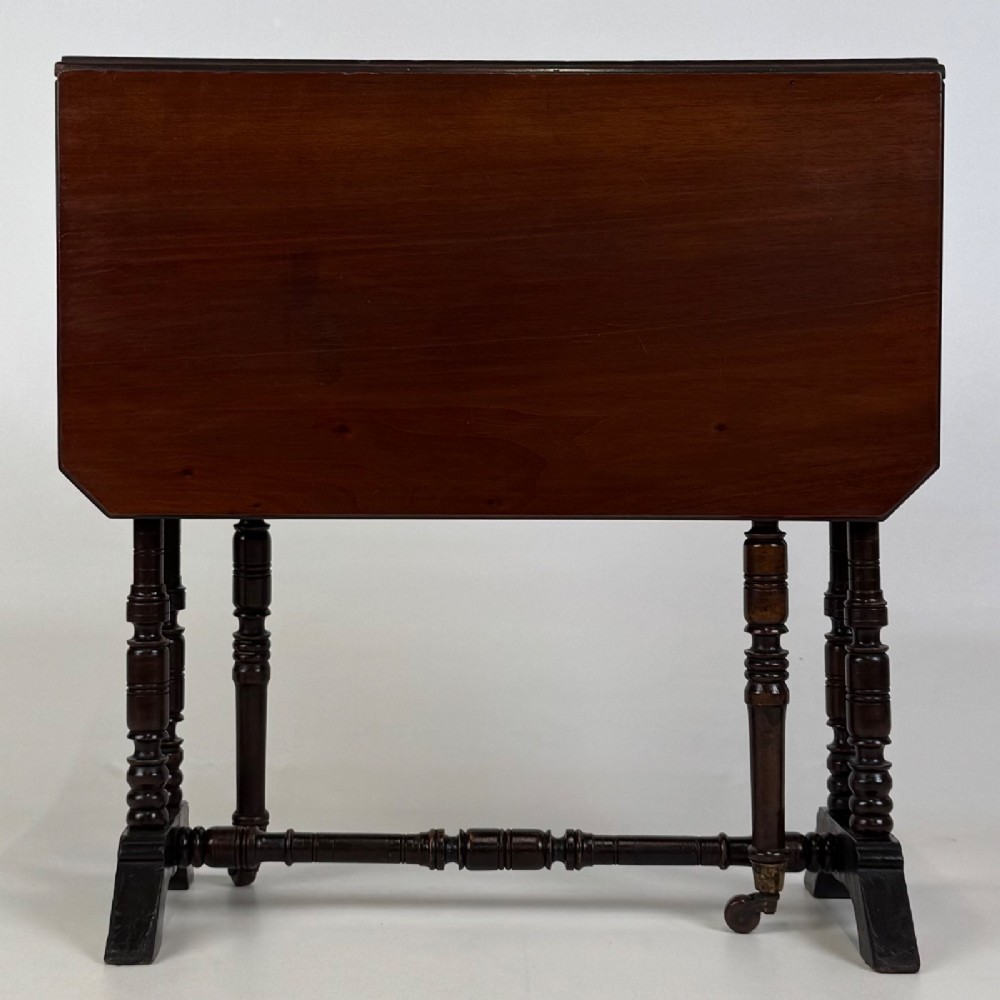 A twentieth-century dark mahogany drop-leaf table featuring turned legs, a central stretcher rail, and folding side flaps. View II