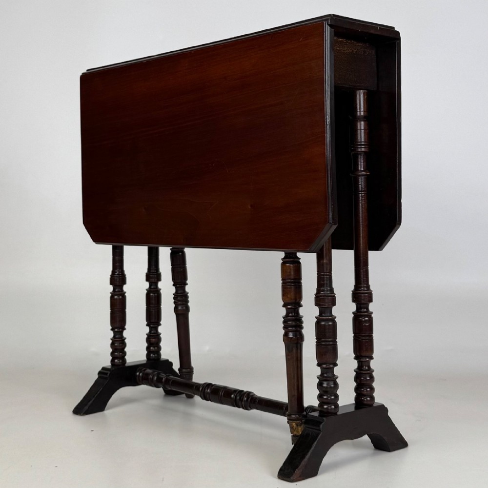 A twentieth-century dark mahogany drop-leaf table featuring turned legs, a central stretcher rail, and folding side flaps. View III