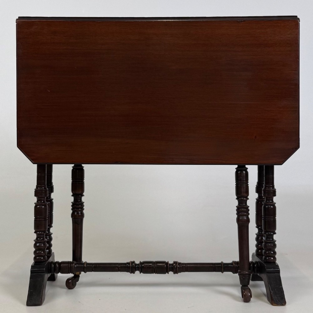 A twentieth-century dark mahogany drop-leaf table featuring turned legs, a central stretcher rail, and folding side flaps. View VII