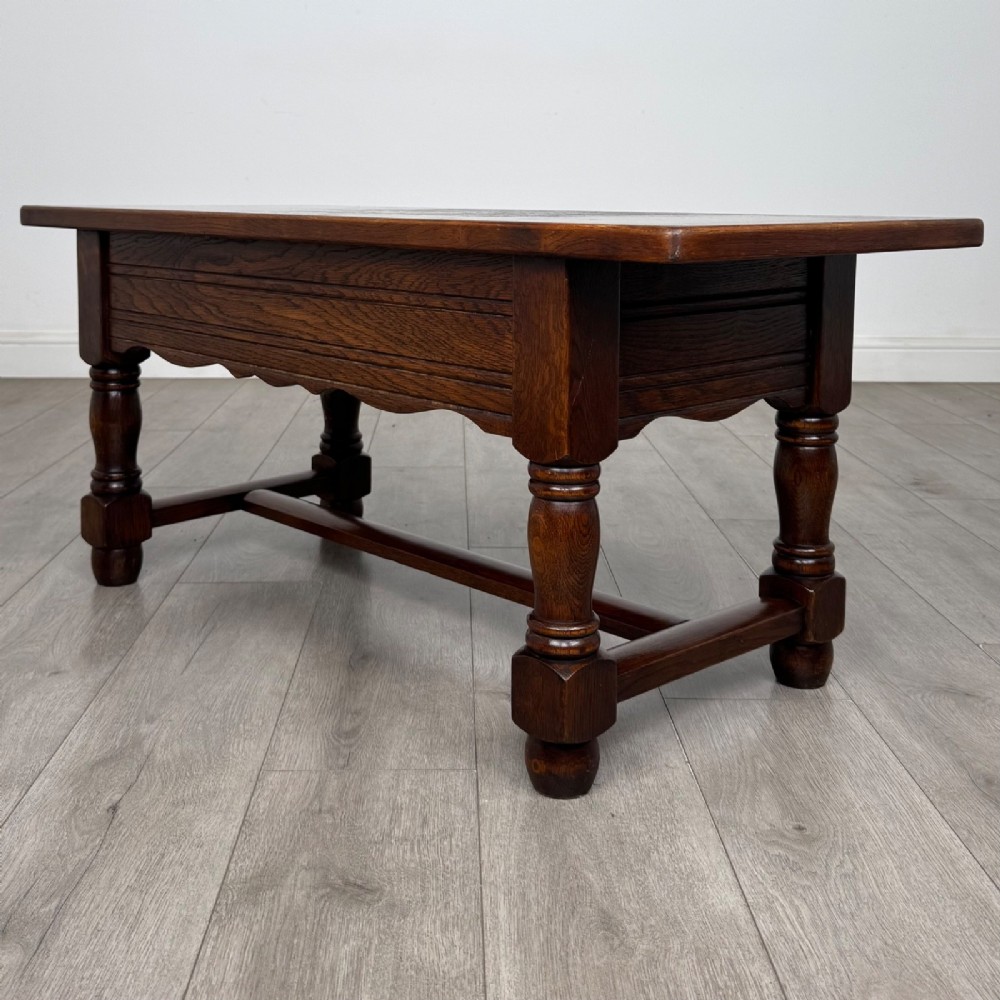 A dark oak rectangular coffee table featuring two front drawers with wooden knob handles and turned baluster legs connected by a low stretcher. View VI