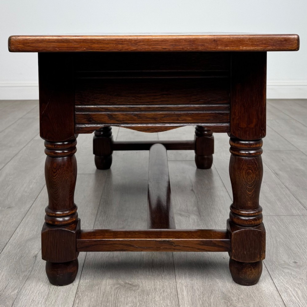 A dark oak rectangular coffee table featuring two front drawers with wooden knob handles and turned baluster legs connected by a low stretcher. View VII
