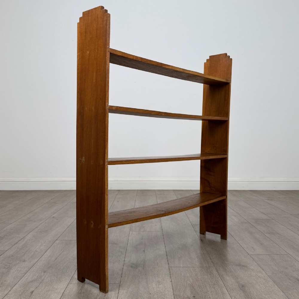 An open-backed 20th-century Arts and Crafts walnut bookcase with four horizontal shelves and notched top end supports. View IV