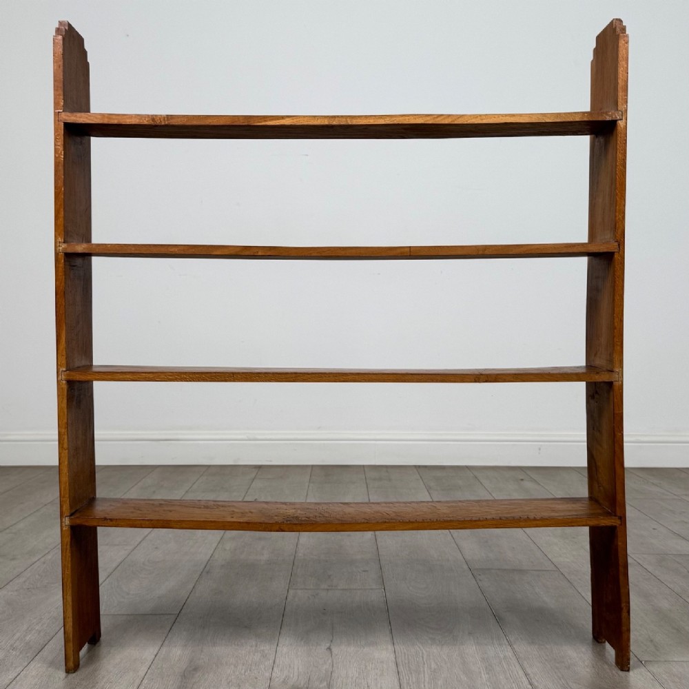 An open-backed 20th-century Arts and Crafts walnut bookcase with four horizontal shelves and notched top end supports. View V