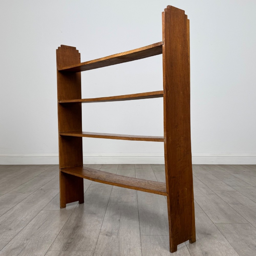 An open-backed 20th-century Arts and Crafts walnut bookcase with four horizontal shelves and notched top end supports. View VI