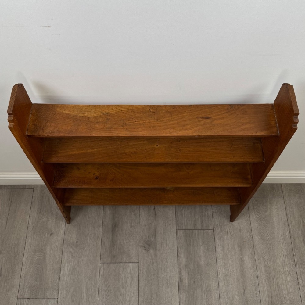 An open-backed 20th-century Arts and Crafts walnut bookcase with four horizontal shelves and notched top end supports. View IX