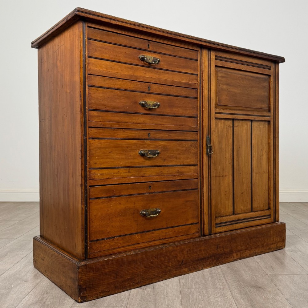 A nineteenth-century warm brown ash wood cupboard featuring four drawers on the left and a panelled cupboard door on the right resting on a plinth base. View IX