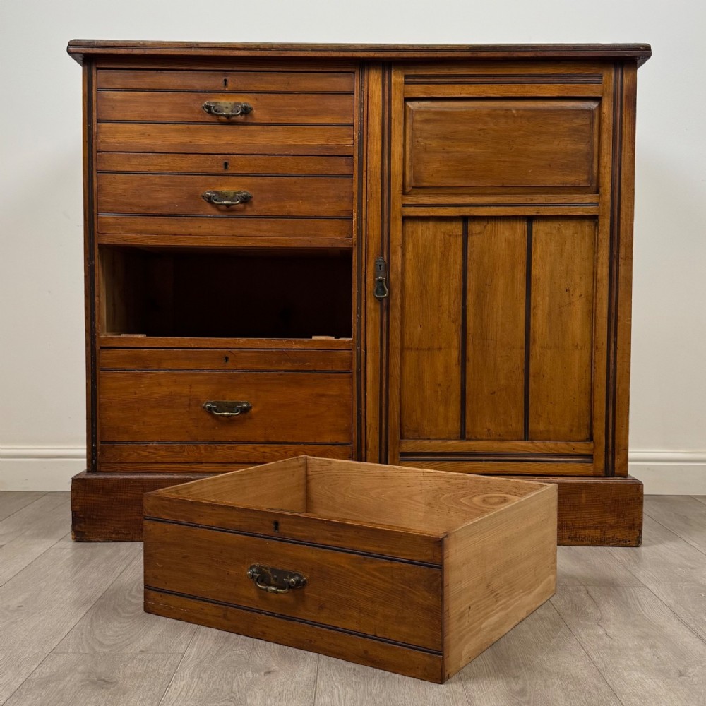 A nineteenth-century warm brown ash wood cupboard featuring four drawers on the left and a panelled cupboard door on the right resting on a plinth base. View XI