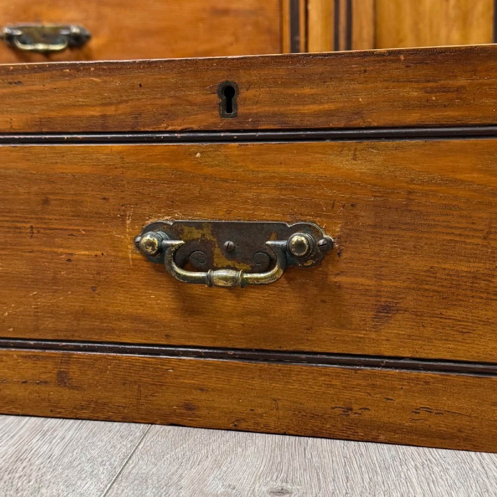 A nineteenth-century warm brown ash wood cupboard featuring four drawers on the left and a panelled cupboard door on the right resting on a plinth base. View XII