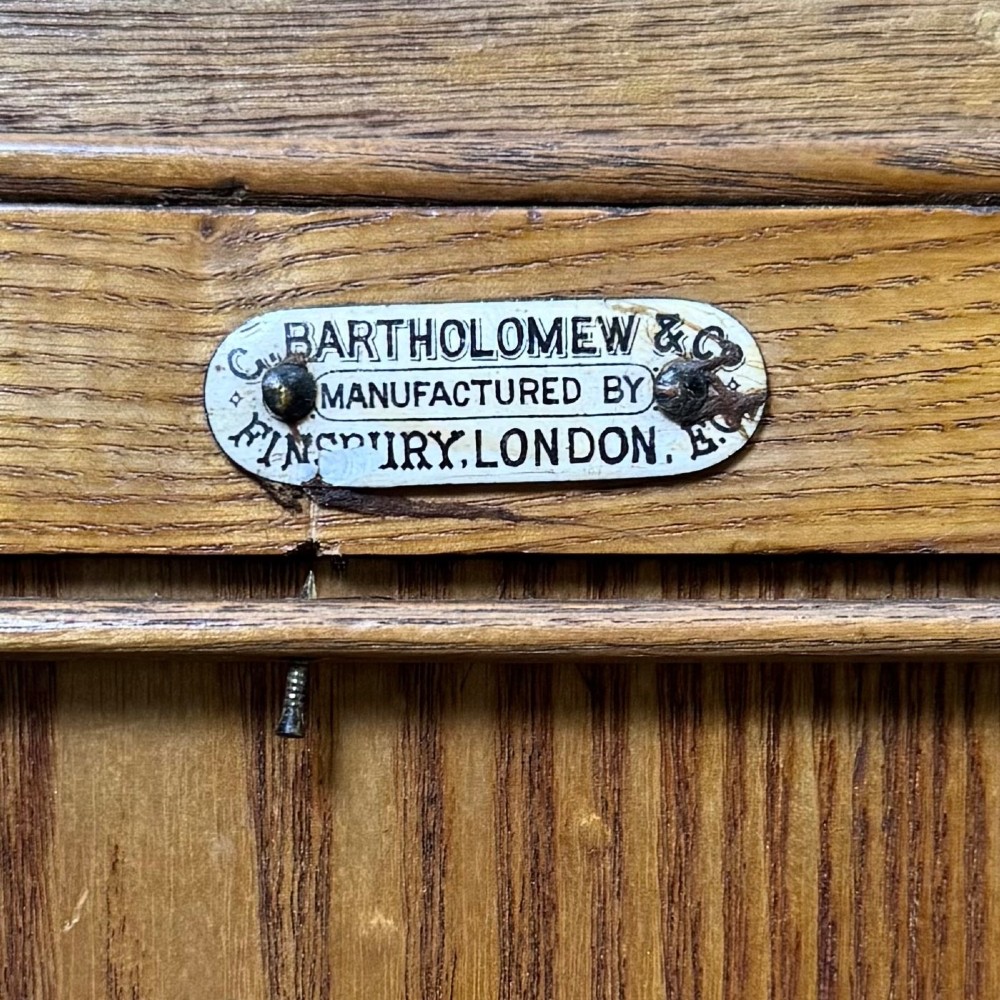 A nineteenth-century warm brown ash wood cupboard featuring four drawers on the left and a panelled cupboard door on the right resting on a plinth base. View XIII