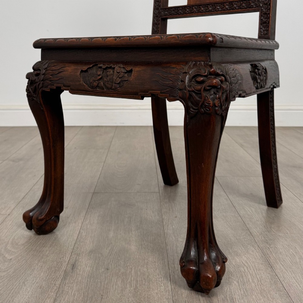 A set of six antique dark rosewood Chinese dining chairs featuring carved back splats, scroll armrests on carvers, carved aprons, and claw feet. View VII