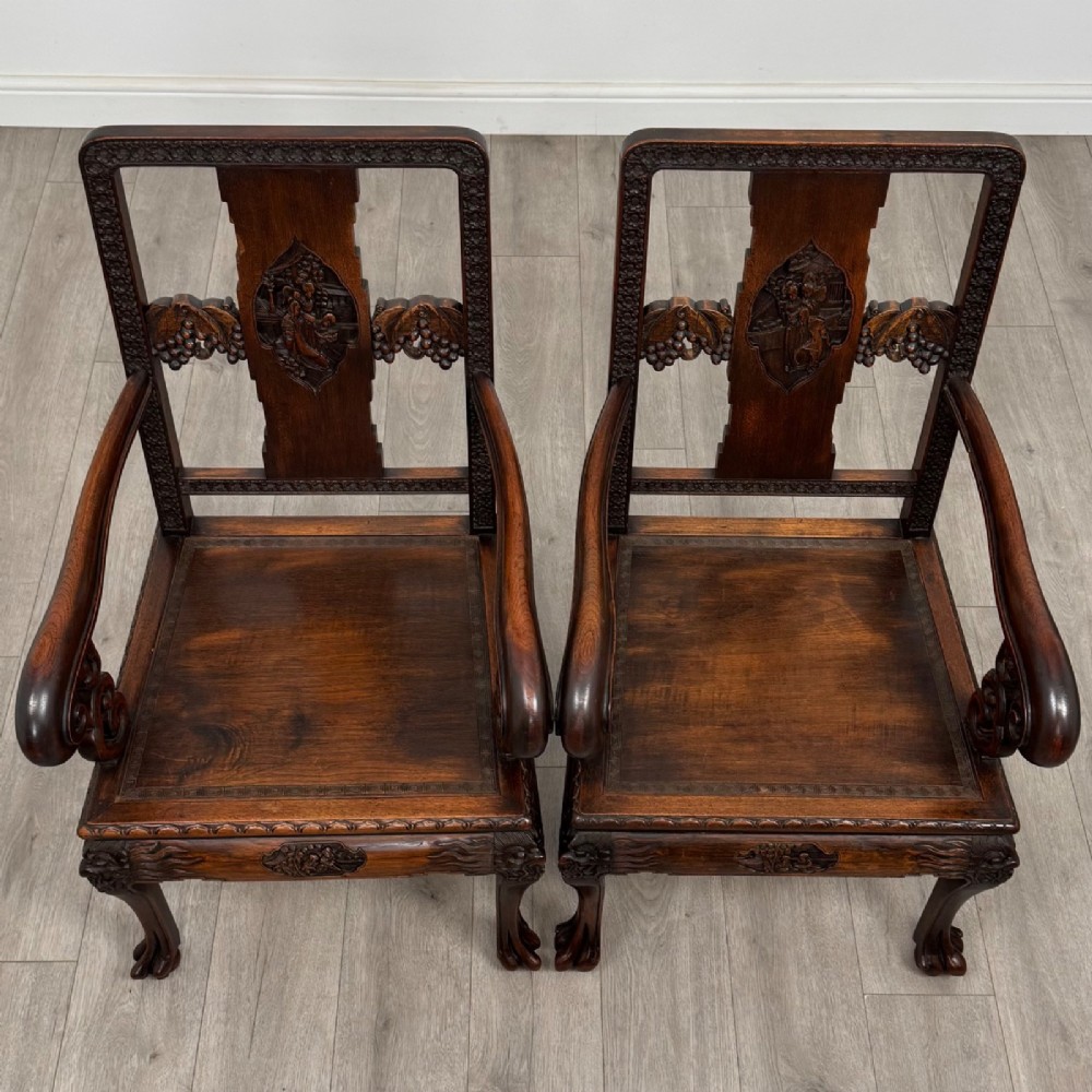 A set of six antique dark rosewood Chinese dining chairs featuring carved back splats, scroll armrests on carvers, carved aprons, and claw feet. View X