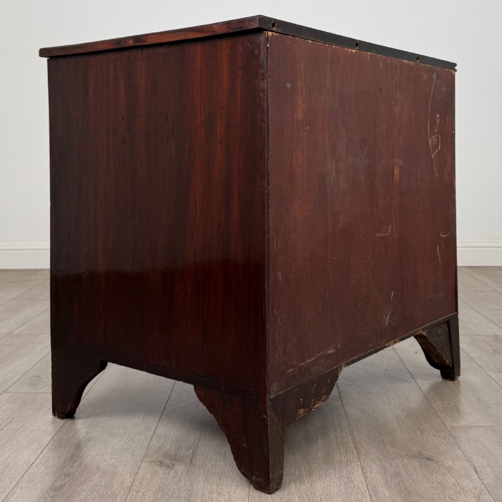 An 18th-century Georgian dark mahogany chest of drawers with two short drawers over three long drawers and brass swan-neck handles. View IV