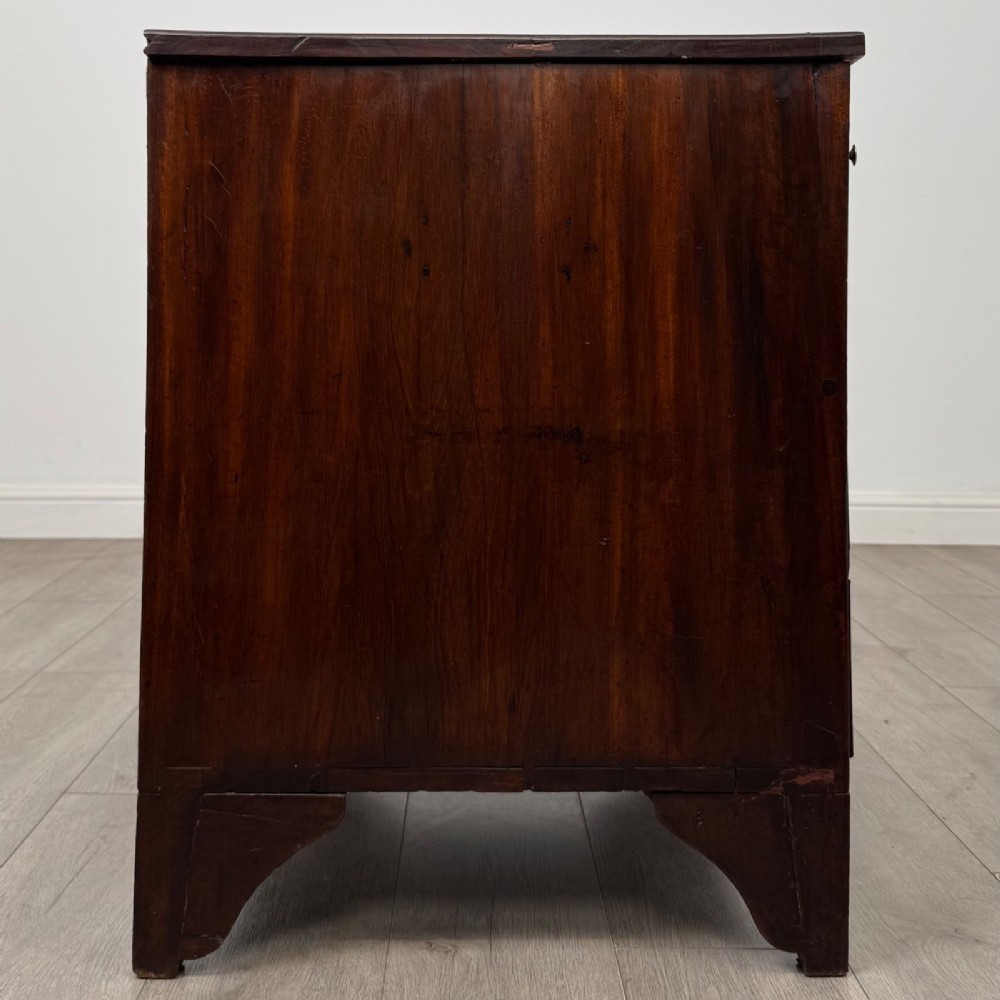 An 18th-century Georgian dark mahogany chest of drawers with two short drawers over three long drawers and brass swan-neck handles. View VII