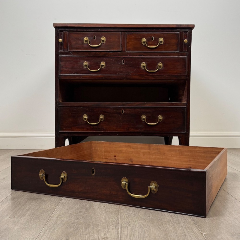 An 18th-century Georgian dark mahogany chest of drawers with two short drawers over three long drawers and brass swan-neck handles. View X
