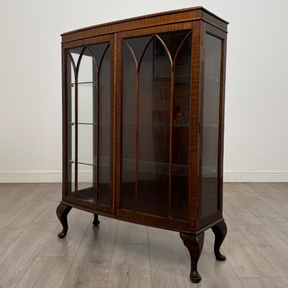 An Edwardian mahogany display cabinet featuring astragal glazed doors with gothic arches, interior glass shelves, and cabriole legs. View III