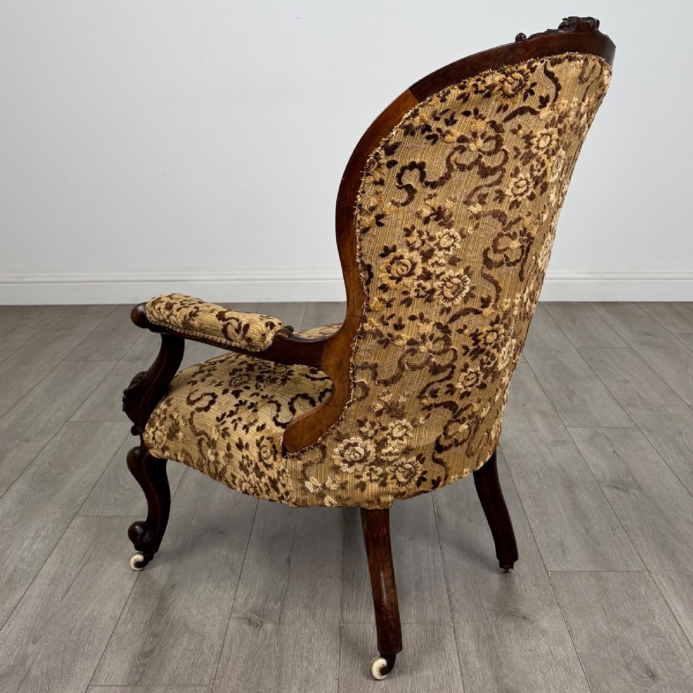 A 19th-century Victorian open armchair constructed from carved walnut wood and upholstered in a patterned gold and brown velvet fabric. View III