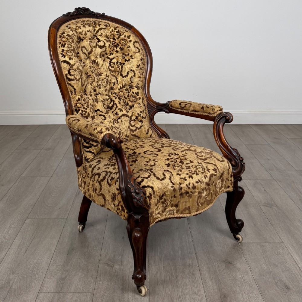 A 19th-century Victorian open armchair constructed from carved walnut wood and upholstered in a patterned gold and brown velvet fabric. View VII
