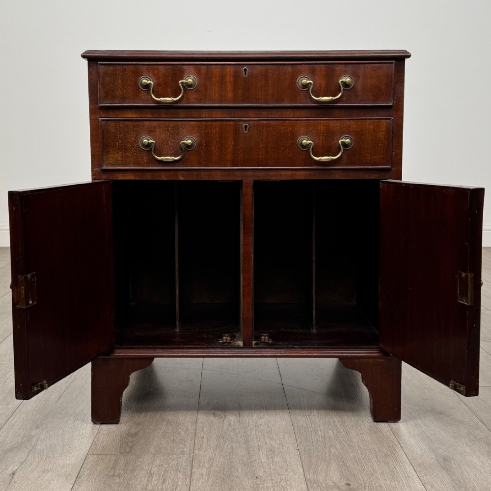 A nineteenth-century dark mahogany small cupboard featuring two drawers with brass swan-neck handles above a double-door compartment set on bracket feet. View II