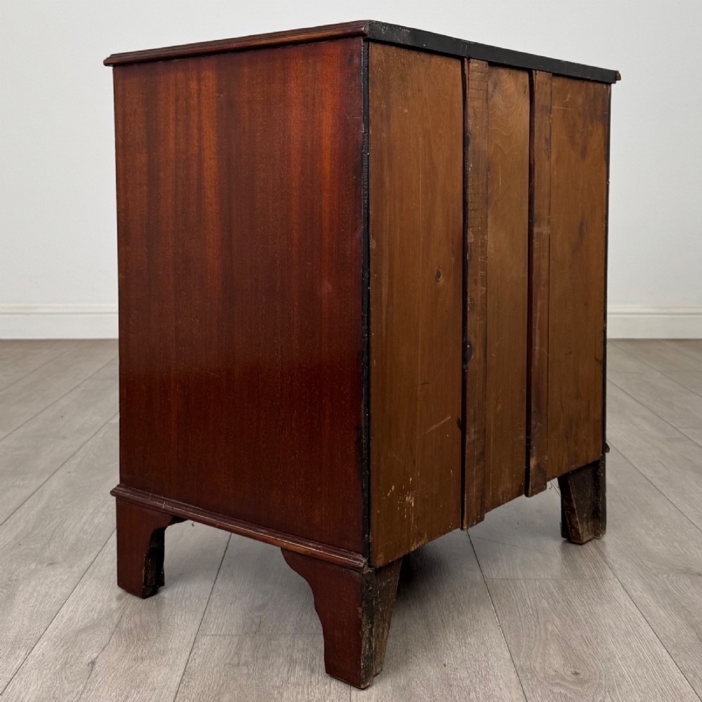 A nineteenth-century dark mahogany small cupboard featuring two drawers with brass swan-neck handles above a double-door compartment set on bracket feet. View V