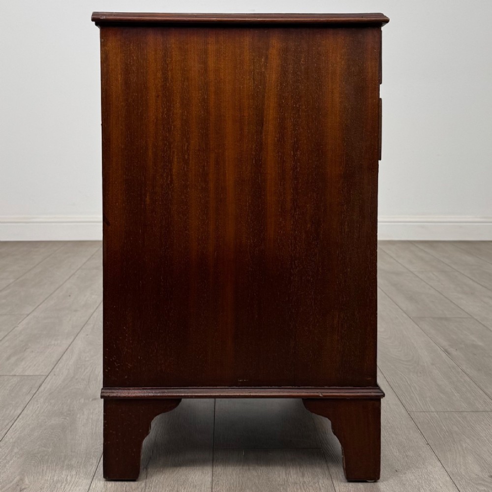 A nineteenth-century dark mahogany small cupboard featuring two drawers with brass swan-neck handles above a double-door compartment set on bracket feet. View VIII