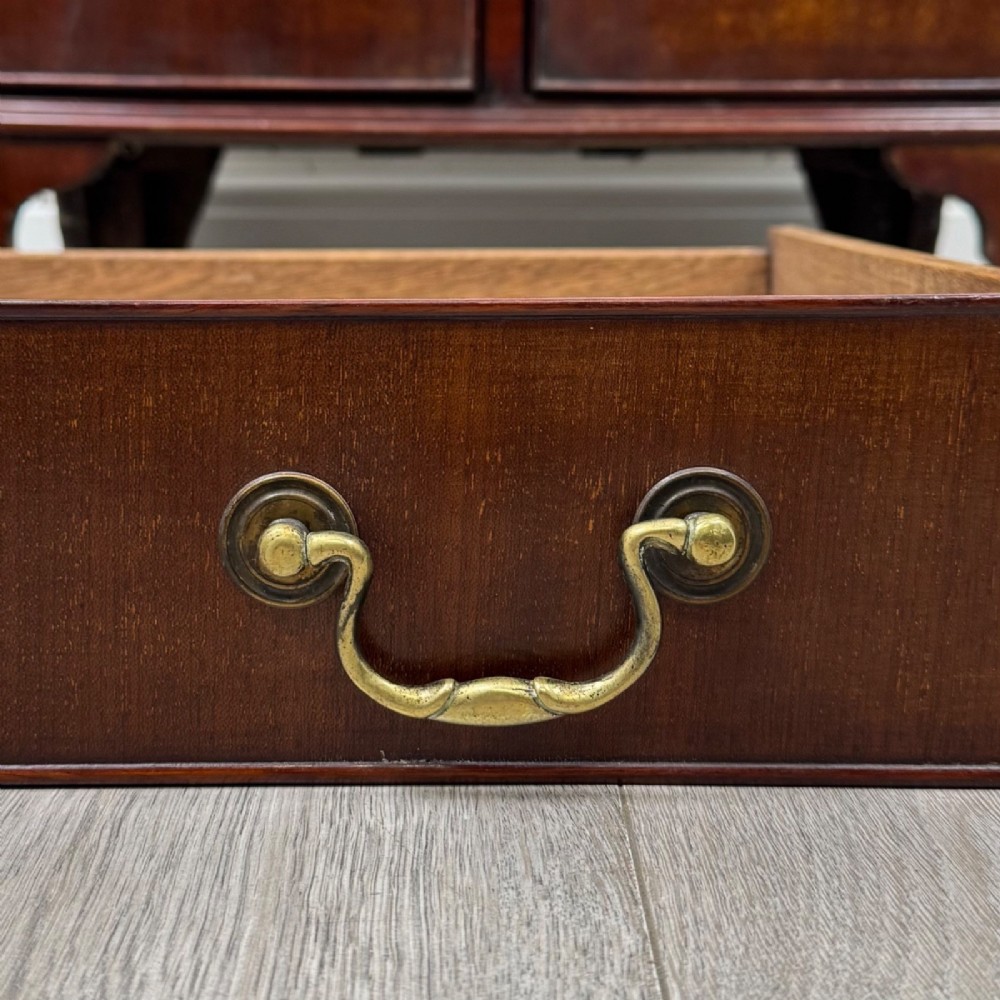 A nineteenth-century dark mahogany small cupboard featuring two drawers with brass swan-neck handles above a double-door compartment set on bracket feet. View XII