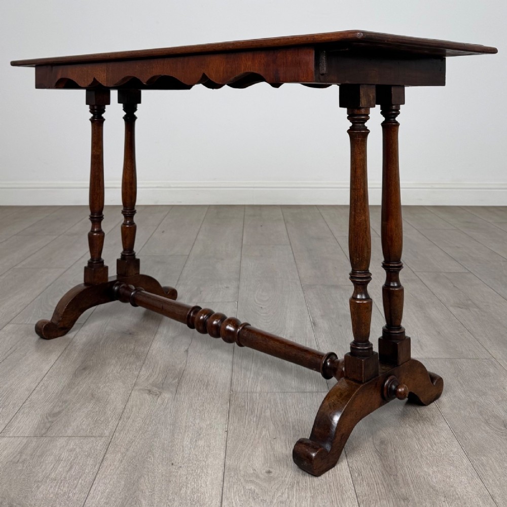 A 19th-century Victorian mahogany side table featuring a rectangular top with a scalloped apron, turned twin-column supports, a central turned stretcher, and curved feet. View II