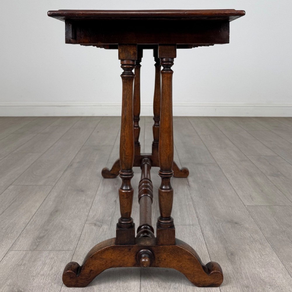 A 19th-century Victorian mahogany side table featuring a rectangular top with a scalloped apron, turned twin-column supports, a central turned stretcher, and curved feet. View III