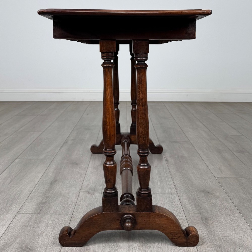 A 19th-century Victorian mahogany side table featuring a rectangular top with a scalloped apron, turned twin-column supports, a central turned stretcher, and curved feet. View VII