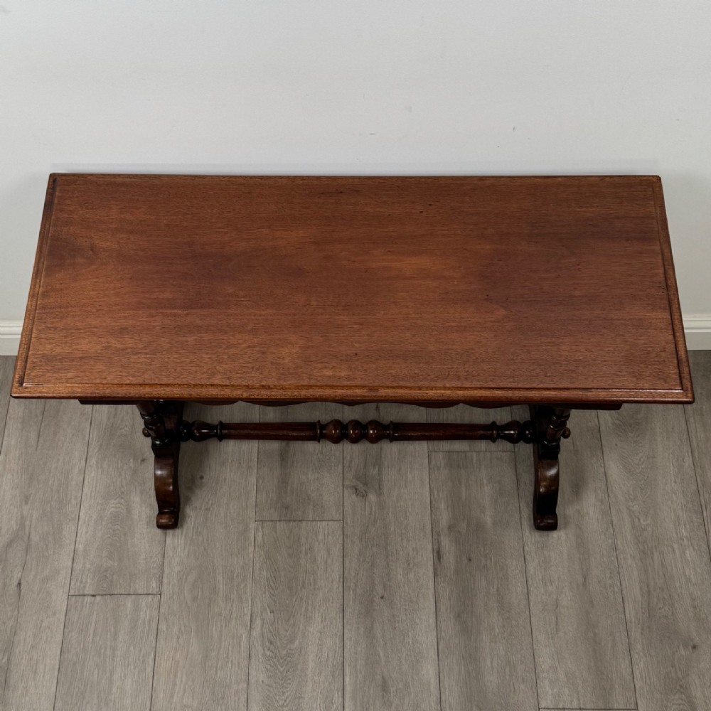 A 19th-century Victorian mahogany side table featuring a rectangular top with a scalloped apron, turned twin-column supports, a central turned stretcher, and curved feet. View IX