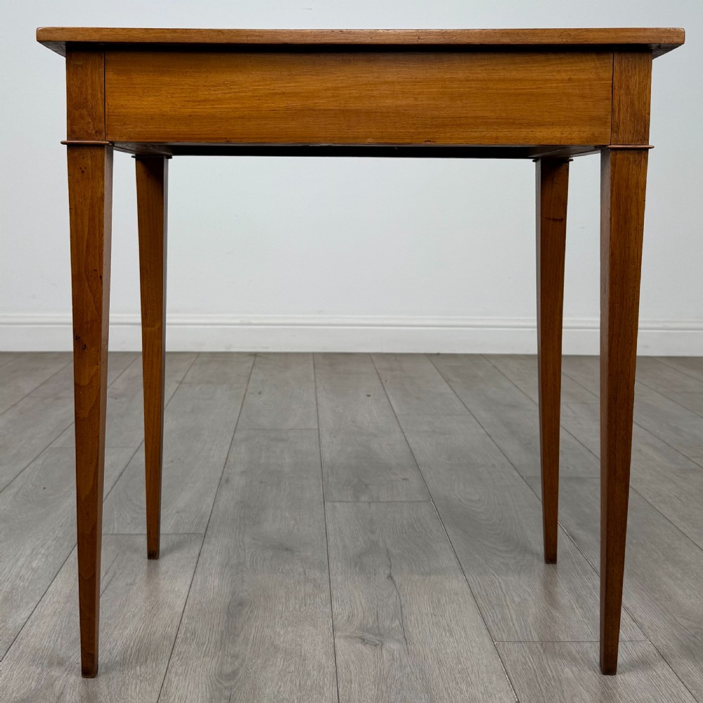An antique early 20th-century walnut side table with a flat rectangular top, plain frieze, and four square tapered legs.