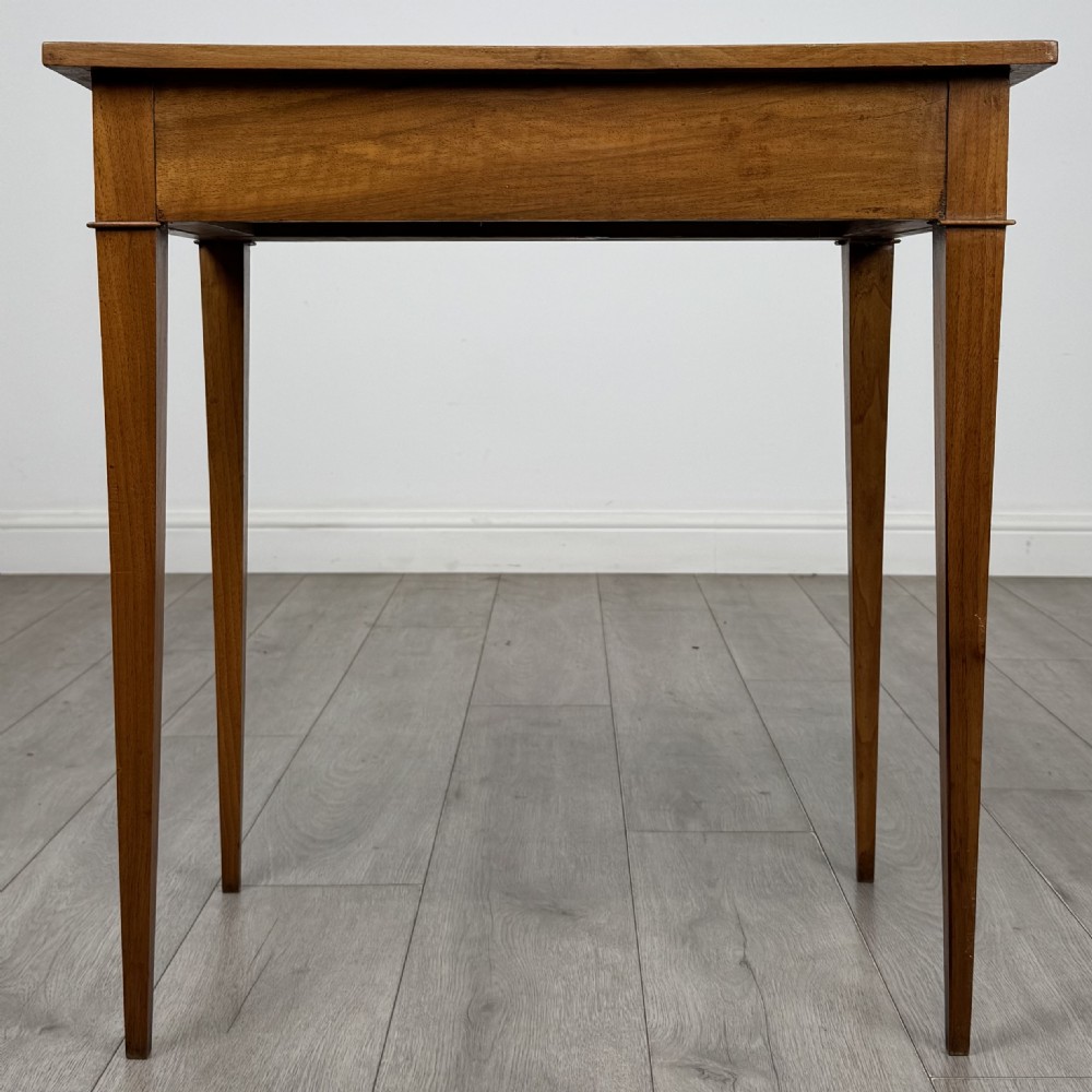 An antique early 20th-century walnut side table with a flat rectangular top, plain frieze, and four square tapered legs. View V