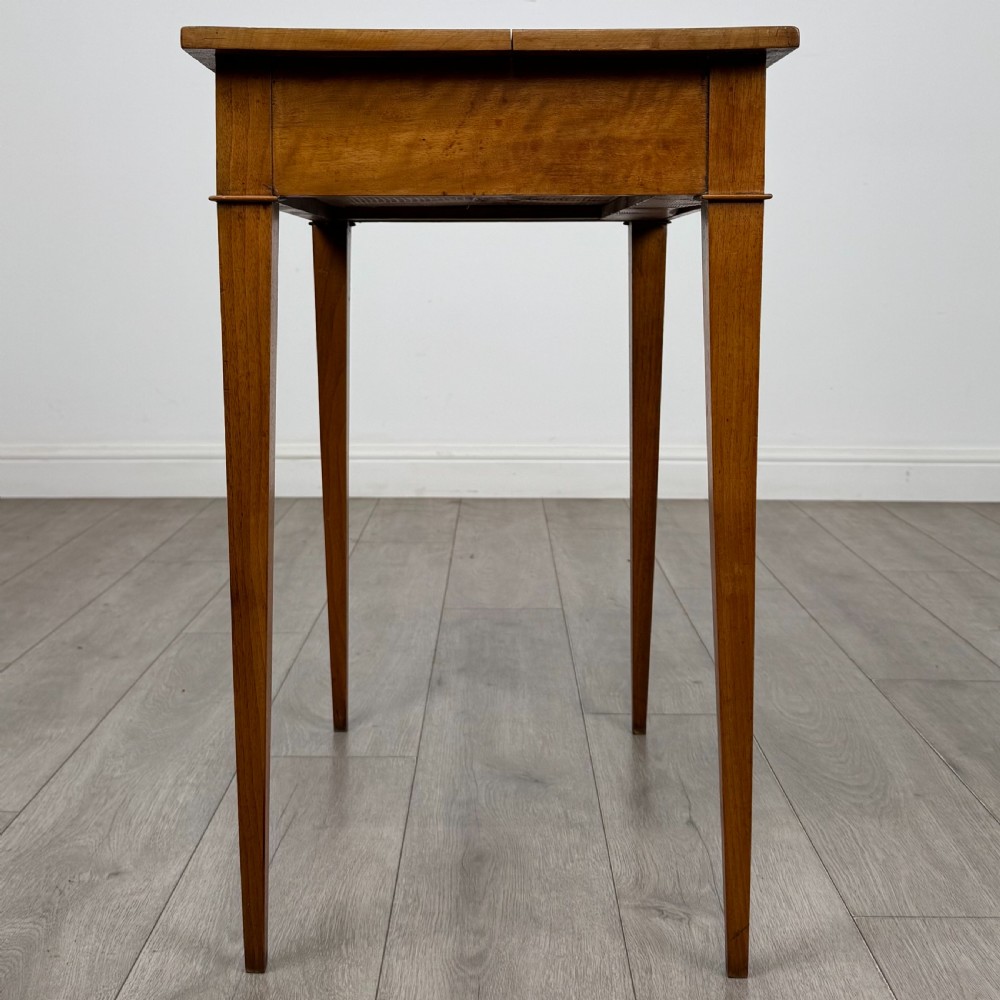 An antique early 20th-century walnut side table with a flat rectangular top, plain frieze, and four square tapered legs. View VII