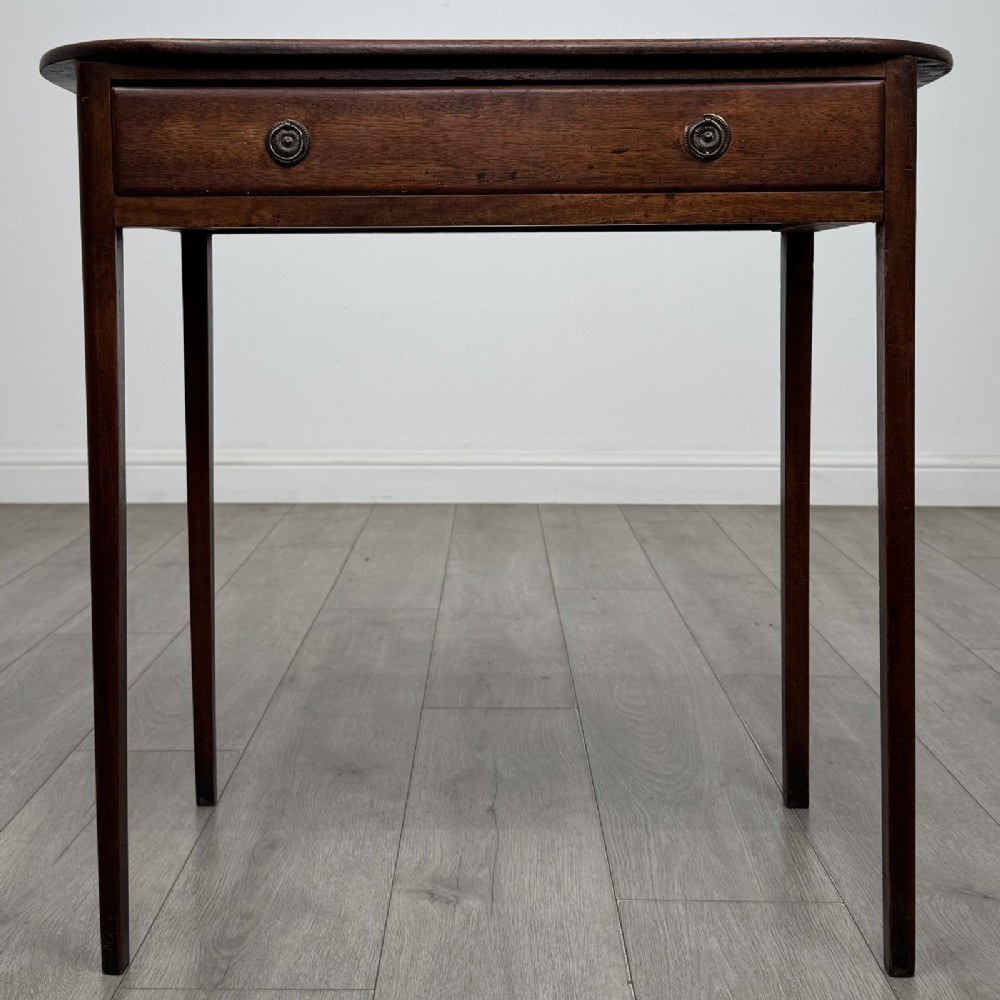 A Georgian style mahogany side table featuring a single drawer with two circular brass handles and straight legs.