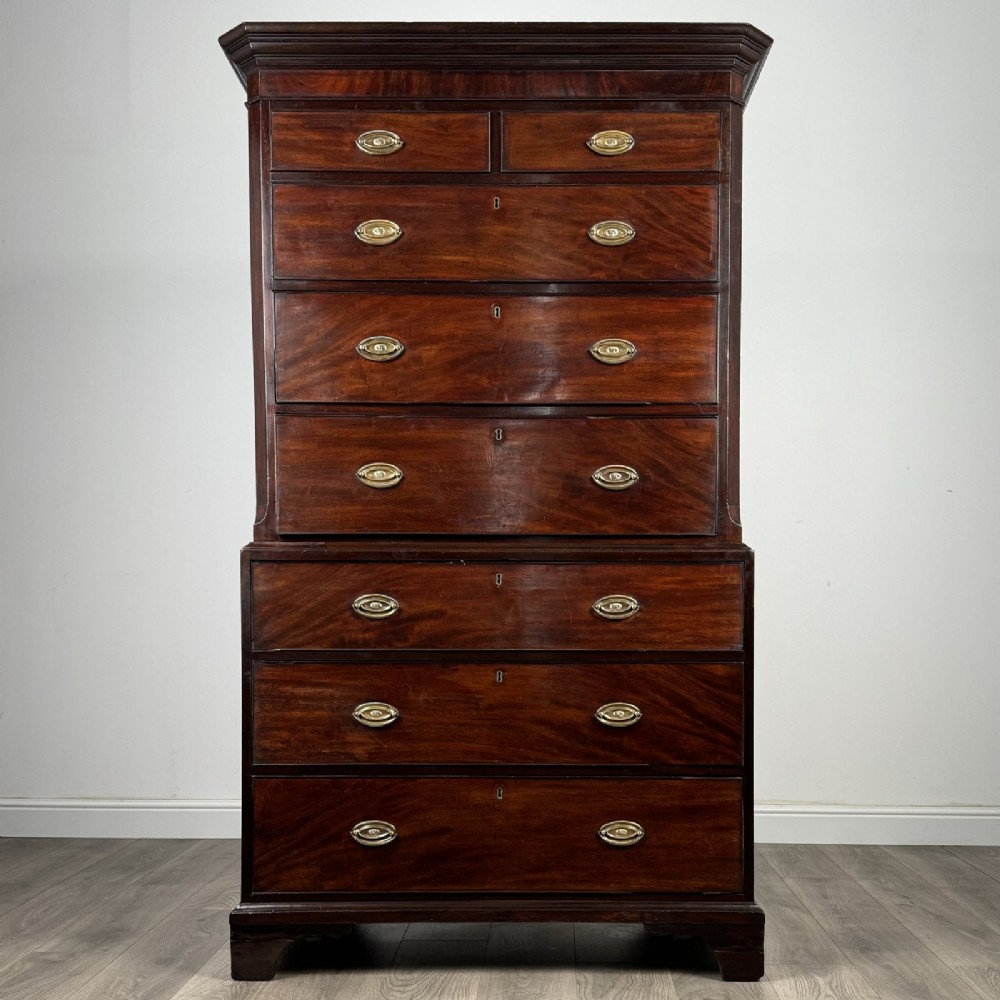 An 18th-century Georgian mahogany chest on chest featuring two short over six long drawers with oval brass handles and bracket feet.