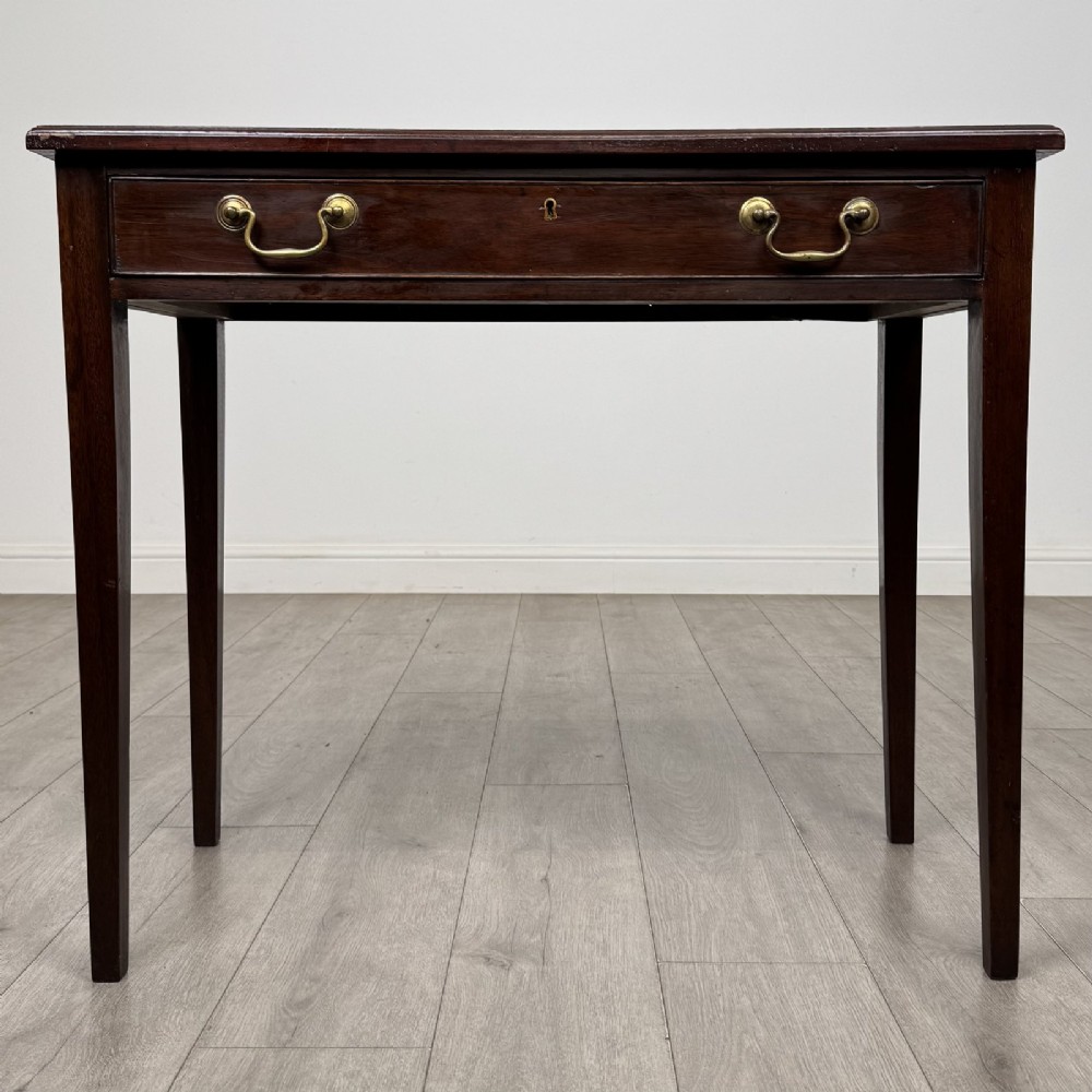 An 18th-century Georgian mahogany writing table featuring a single long drawer with two brass swan-neck handles and four square tapered legs.