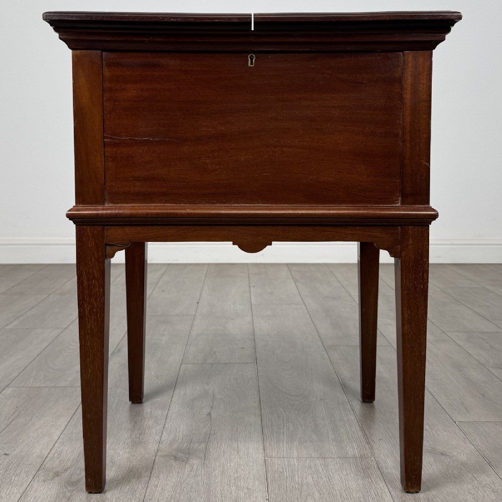 A 19th-century mahogany fold-out cabinet standing on four square tapered legs with a brass keyhole escutcheon on the front casing.