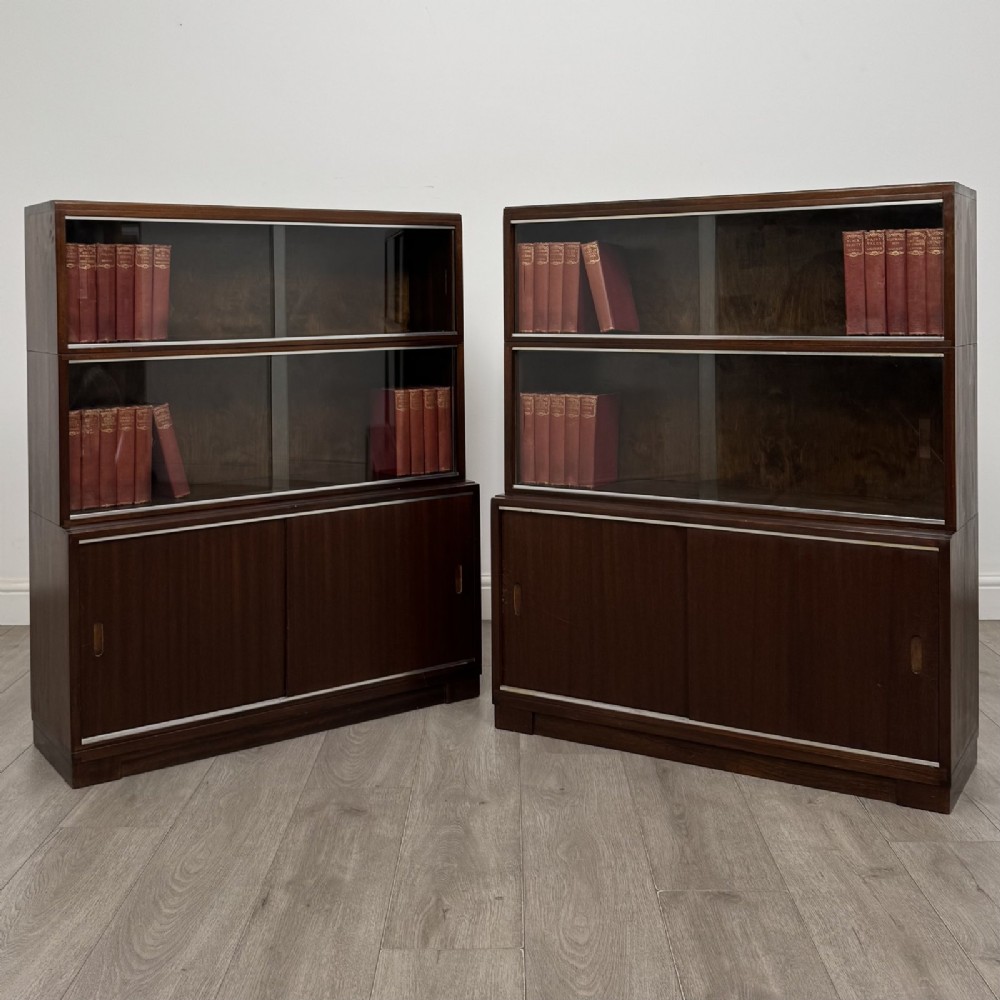 A pair of dark mahogany display cabinets featuring sliding glass upper doors and solid wooden sliding lower doors.