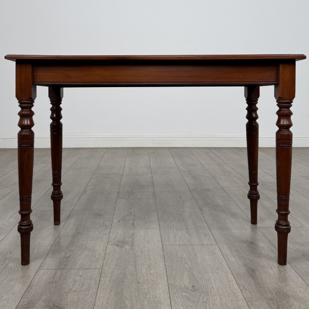 An Edwardian walnut side table featuring a rectangular top, plain apron, and four reeded turned legs.