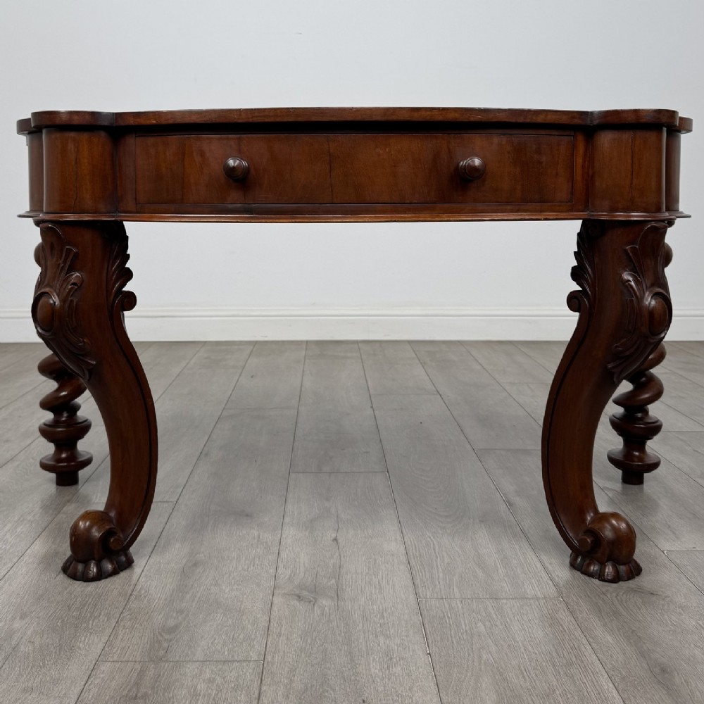 A Victorian mahogany console table with carved cabriole front legs, spiral rear legs, and a single drawer with round wooden handles.