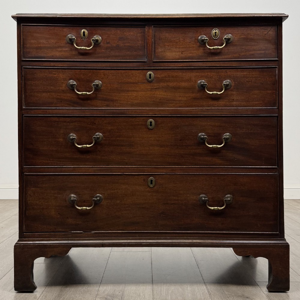 An 18th-century Georgian mahogany chest of drawers featuring a two-over-three drawer configuration with brass swan-neck handles and bracket feet.