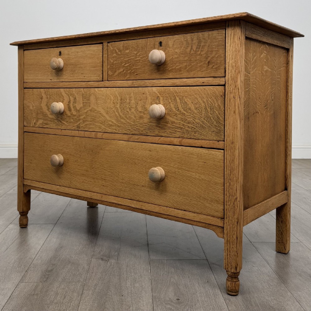 An Edwardian quarter-sawn oak chest of drawers with two short drawers over two long drawers and turned wooden handles. View II