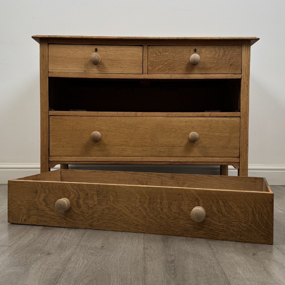 An Edwardian quarter-sawn oak chest of drawers with two short drawers over two long drawers and turned wooden handles. View X