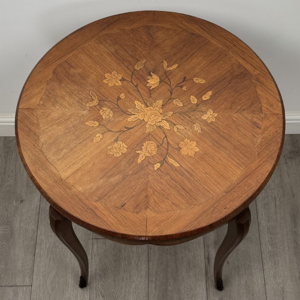A circular French Louis XV style lamp table featuring slender cabriole legs, marquetry wood grain pattern, an undulating apron, and metal sabot feet. View VII