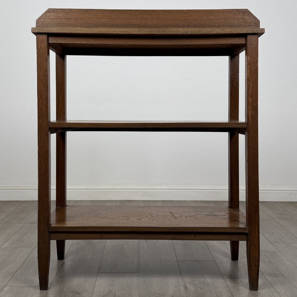 An antique Edwardian dark oak buffet featuring three open rectangular shelves supported by straight tapered legs. View V