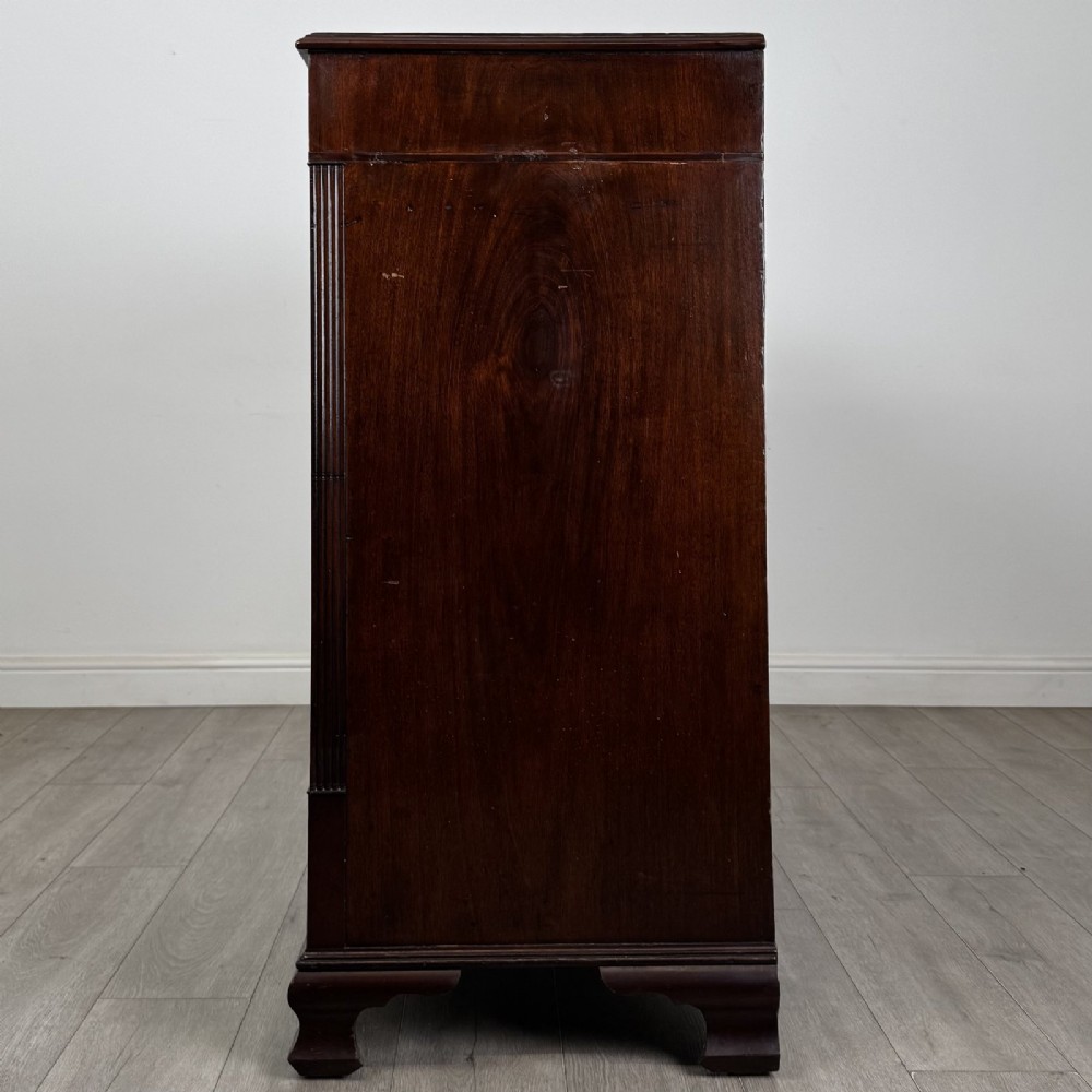 An 18th-century Georgian mahogany chest of drawers featuring inlaid stringing along the top frieze, two short drawers above three long drawers, brass swan-neck handles, fluted pilasters, and bracket feet. View III