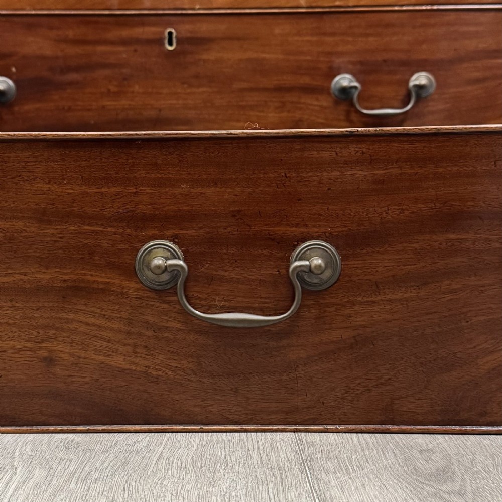 An 18th-century Georgian mahogany chest of drawers featuring inlaid stringing along the top frieze, two short drawers above three long drawers, brass swan-neck handles, fluted pilasters, and bracket feet. View XI