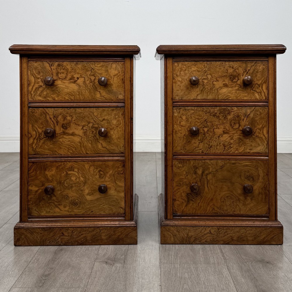A pair of Victorian burr walnut bedside cabinets featuring three drawers each with turned wooden knobs and a plinth base. View II