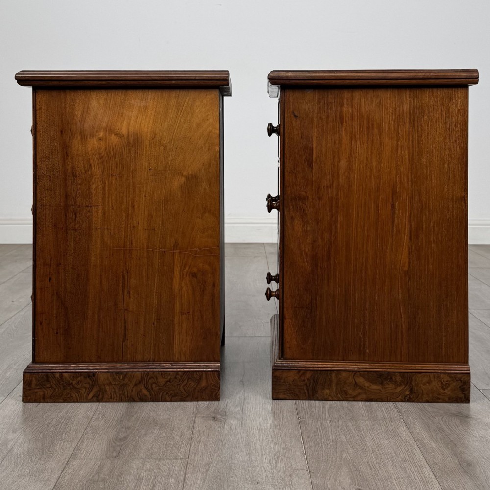 A pair of Victorian burr walnut bedside cabinets featuring three drawers each with turned wooden knobs and a plinth base. View IV